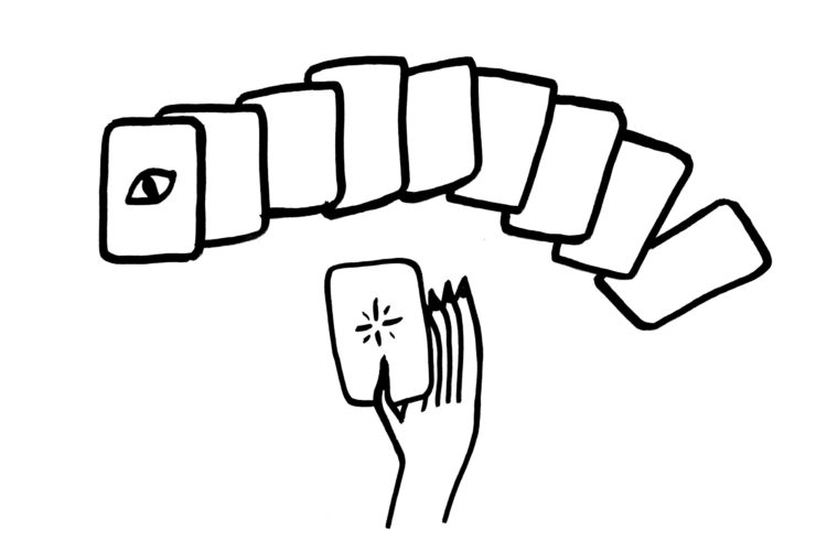 A fan spread of tarot cards with a hand drawing a card out